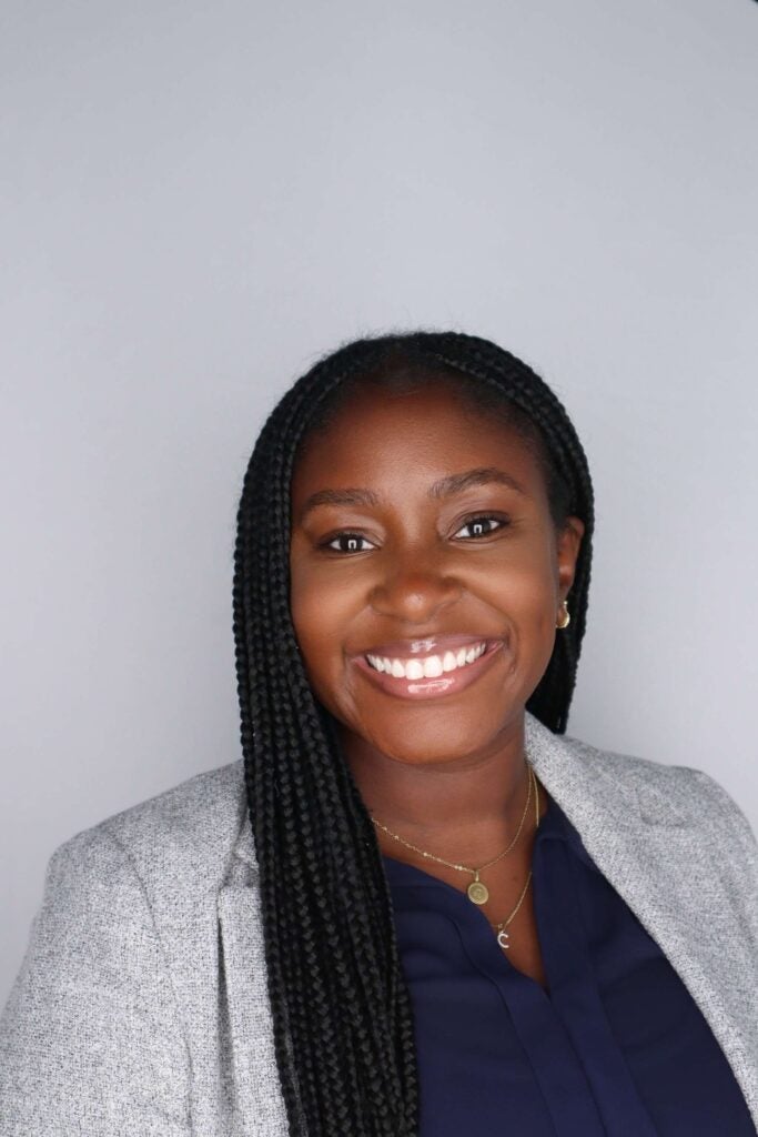 Catherine Sayikanmi, a Black woman, smiling straight ahead