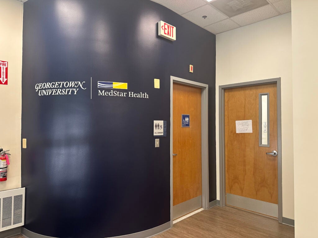 Additional waiting area in the Student Health Center renovations, including a blue accent wall with branding and two doors. 
