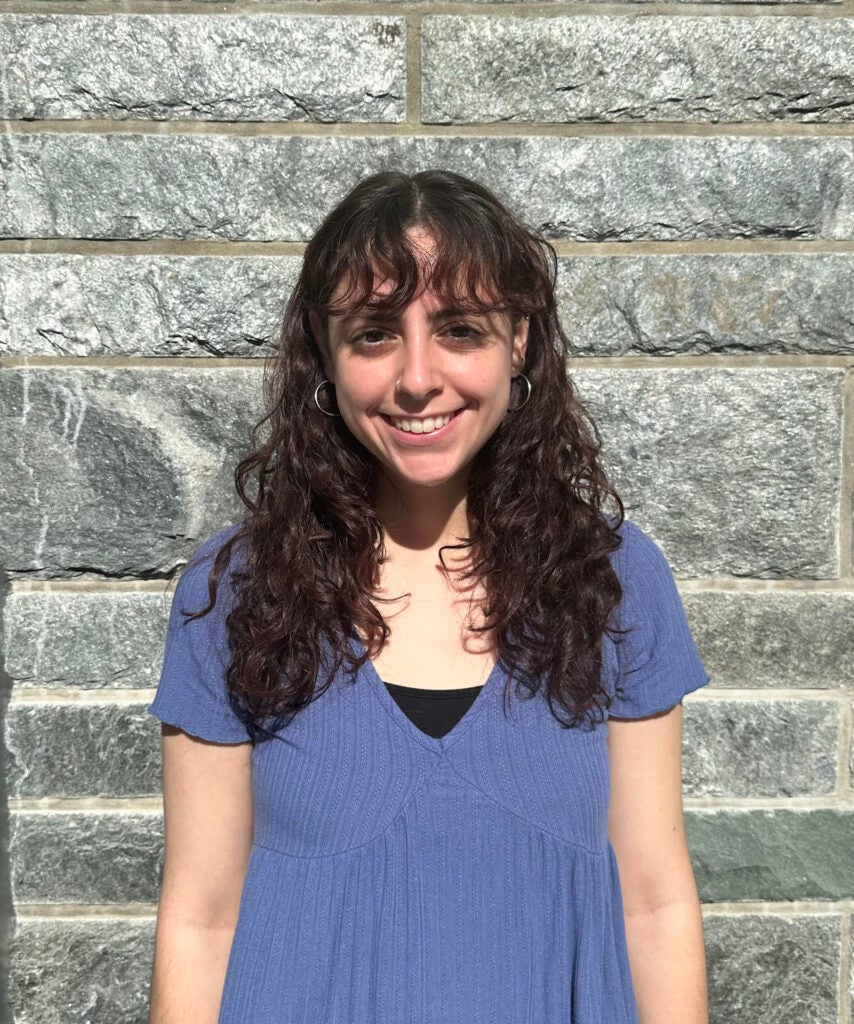 Smiling female with brown hair and blue top.